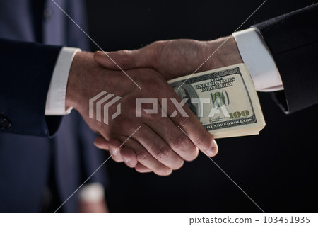 Handshake with the transfer of money on a black background 103451935