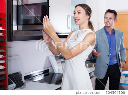 Seller and woman at kitchen furniture 104504100