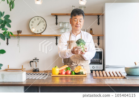 Asian middle-aged and elderly men who cook with vegetables in the kitchen at home (broccoli) 105404115