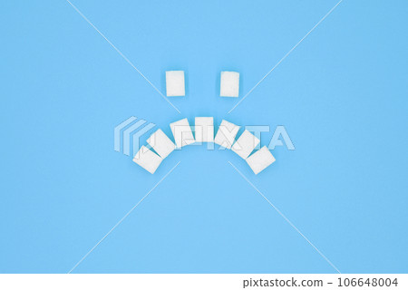 Sad face symbol, composed of cubes of sugar. 106648004