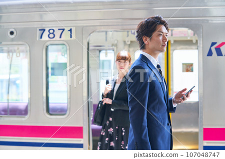 Young man and woman on the station platform Photography provided by Keio Electric Railway Co., Ltd. 107048747