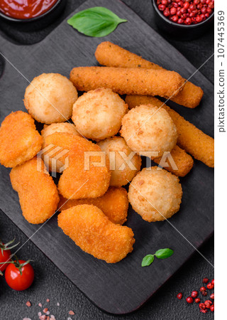 Delicious nuggets, sticks and balls of mozzarella and parmesan cheese with salt and spices 107445369