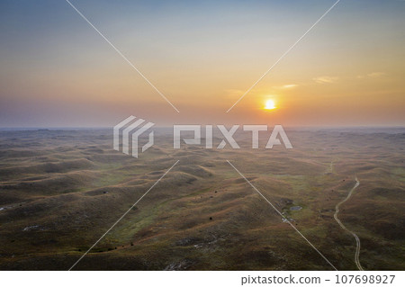 hazy sunrise over Nebraska Sandhills at Nebraska National Forest, aerial view of fall scenery affected by wildfire smoke from Colorado and Wyoming 107698927