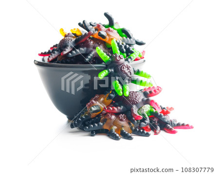 Scary sweet jelly spiders. Halloween candies in bowl isolated on white background. 108307779