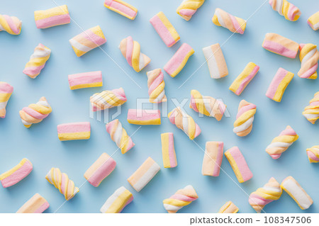 Sweet colorful marshmallows on blue background. Top view. 108347506