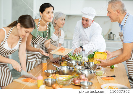 Friendly Asian woman talking to elderly man during culinary classes 110637862