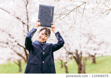 High school/high school girls placing their diplomas on their heads under cherry blossoms in full bloom (graduation/graduation/graduation ceremony) 110996879