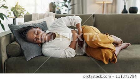 Home, pain and black woman on a couch, cramps and stomach with sickness, suffering and disease in the living room. African person, apartment and girl with abdominal problem, tummy ache and period 111375784