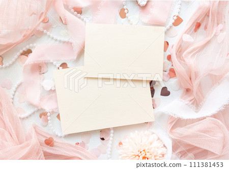 Cards near pink decorations, hearts and silk ribbons on white table top view, mockup 111381453