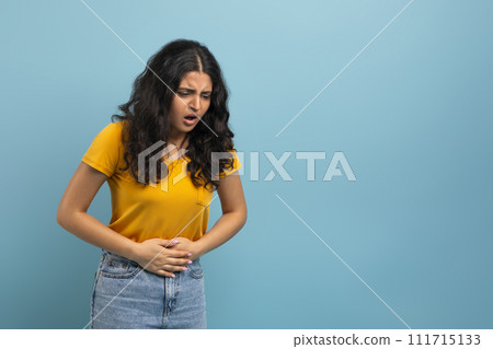 Young indian woman with abdominal pain, copy space 111715133