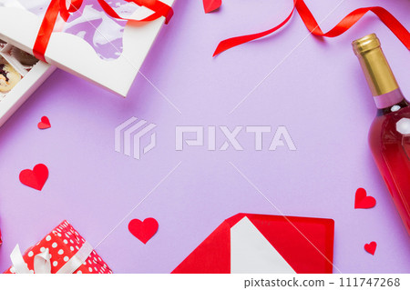 top view photo of st valentine day decor shopping, bag, wine, bottle, envelope, gift, box, candy and red heart on colored background with empty space. Frame background 111747268