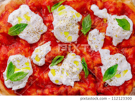 Italian pizza with mozzarella cheese and tomato topped with fresh basil 112123300