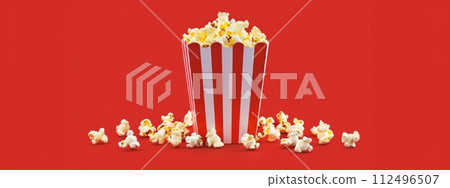 AI-generated content. Popcorn in the paper red and white box isolated on the red background 112496507