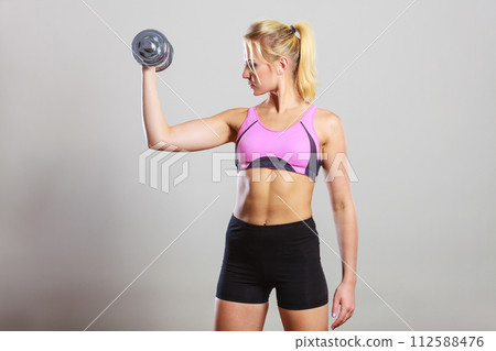 Fit woman lifting dumbbells weights 112588476