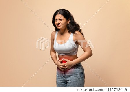 Sick indian woman having stomach ache, touching abdomen with red inflamed zone 112718449