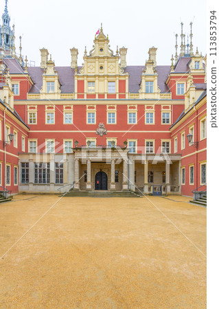 The front view of Chateau Bad Muskau, with visitors on the entrance steps, under a grey, overcast sky. Saxony, Germany 113853794