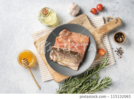 Raw salmon, greased with honey marinade with spices on a plate on a light background  115132065