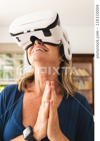 Middle-aged Caucasian woman enjoying virtual reality experience indoors 116310004