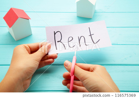 The word Rent written on paper and cut in half with a pair of scissors 116575369