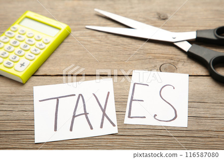 Text of tax and scissors, concept of tax cut on grey background 116587080