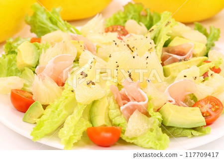 Tosa Buntan, prosciutto and avocado salad. Large citrus fruits. Light background. 117709417