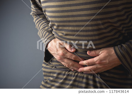 Abdominal Pain. Man holds his stomach and has hurt 117843614