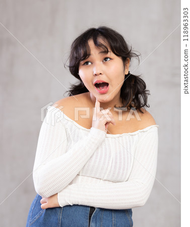 Portrait of surprised young girl posing in studio 118963303