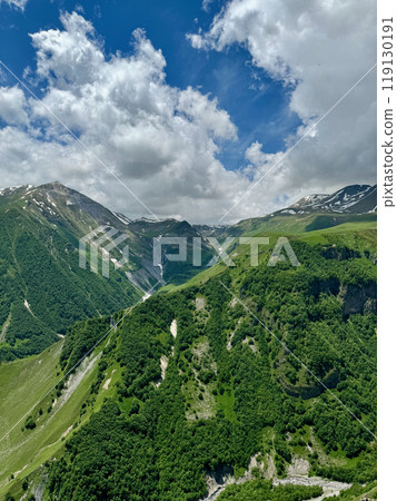 Panoramic landscape of green Caucasus mountains in sunny weather with cloudy sky 119130191