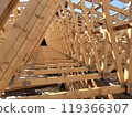 Perspective view down rows of wooden trusses, emphasizing the geometric layout and precision of the construction 119366307