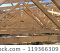 Long row of angled wooden trusses forming a structural frame, emphasizing the orderly layout under bright daylight 119366309