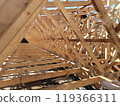 Wooden trusses arranged in a repetitive pattern, creating a tunnel-like effect in a large construction project 119366311