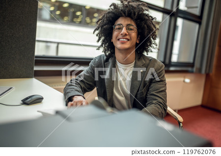 Man sitting at the table in the library 119762076