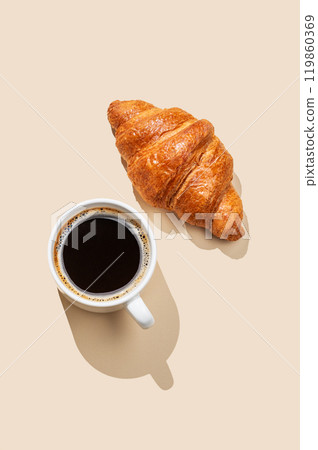 Coffee espresso cup and fresh croissant  on a yellow  background.  119860369