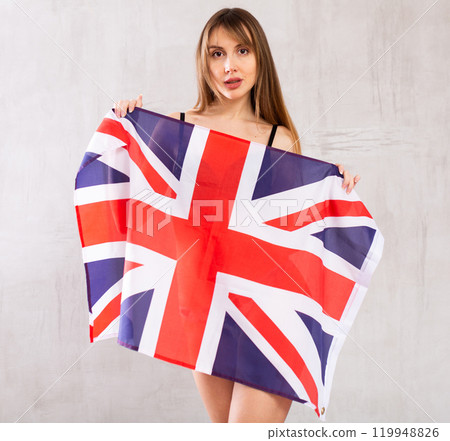 Young woman hiding behind flag of Great Britain 119948826