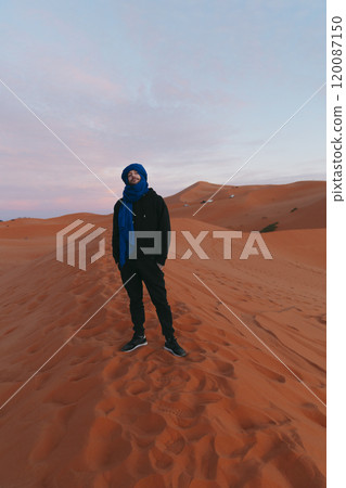 Man with a Berber scarf on the top of a dune at Sahara desert 120087150