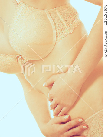 Woman in lingerie with stomach pain 120155670