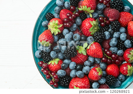 Mix of ripe colorful berries in bowl photography . Blueberry , strawberry , raspberry , blackberry and red currant . Top view 120268921