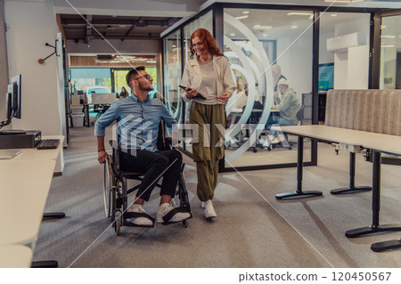 Young business colleagues, collaborative business colleagues, including a person in a wheelchair, walk past a modern glass office corridor, illustrating diversity, teamwork and empowerment in the 120450567