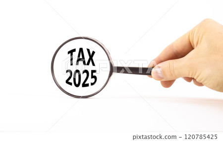 Planning tax 2025 new year symbol. Concept words Tax 2025 on beautiful white paper in magnifying glass. Businessman hand. Beautiful white background. Business tax 2025 new year concept. Copy space. 120785425