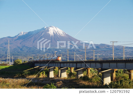 開往岡山的最新273系列特急「八雲22號」在第一場雪中穿過日野川大橋向大山山麓高速行駛。 120791592