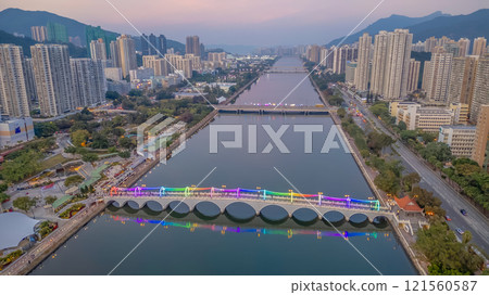 Colorful Illuminated Pedestrian Bridge Above Calm Water at Dusk Dec 22 2024 121560587