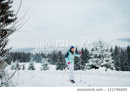 Beautiful woman is cross country skiing in winter nature. Active winter holidays in a mountains. 121746869