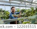 Male bearded greenhouse worker looking involved and busy 122035515