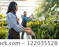 Greenhouse workers watering flowers in a glasshouse 122035528