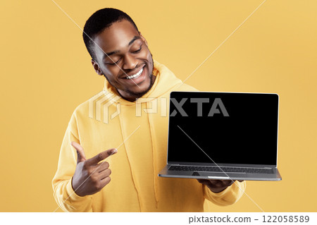 Black Young Man Showing Laptop Computer Blank Screen Advertising Great Website Posing Over Yellow Studio Background. Mockup For Advertisement. People And Gadgets, Internet And Technology Concept 122058589