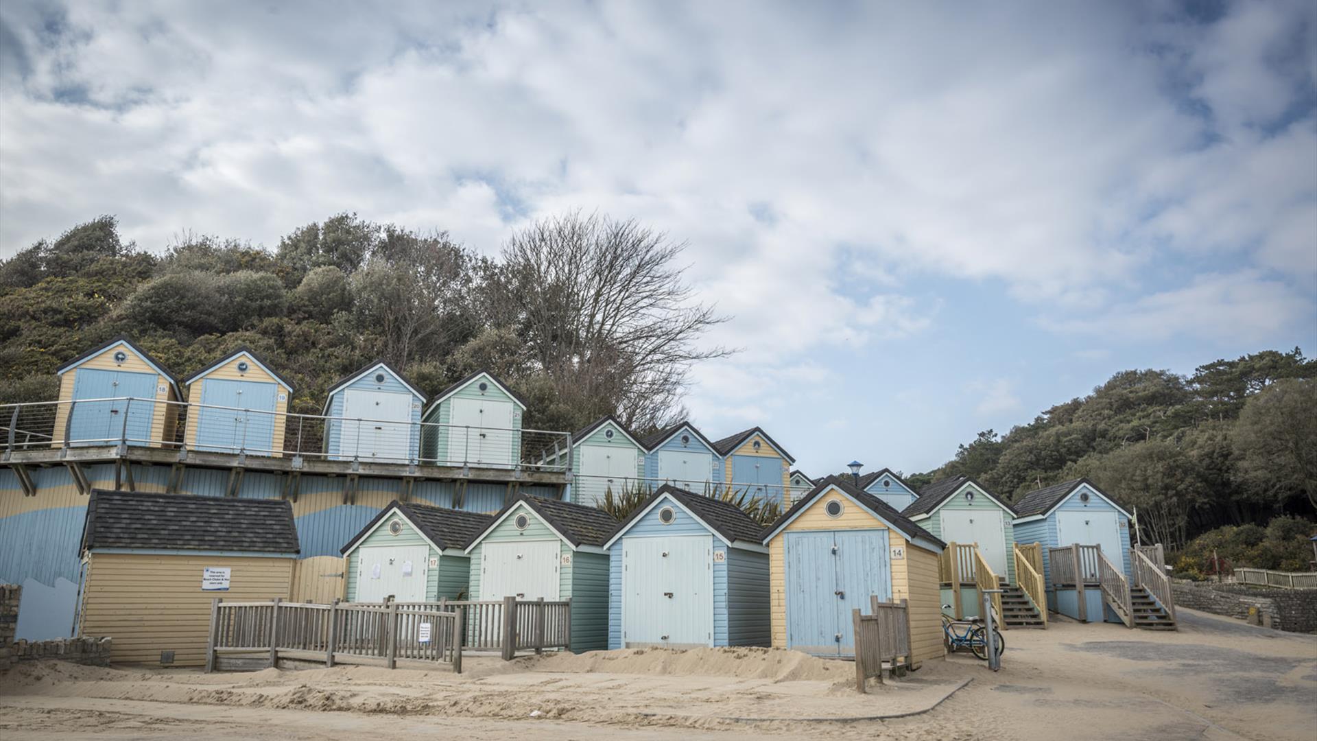 Selection of huts on different levels with sand around them