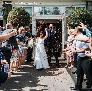 Wedding guests throwing confetti on the bride and groom outside of The Royal Hotel in Ventnor, Isle of Wight