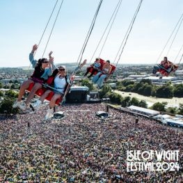 People enjoying a ride with an aerial view of the Isle of Wight Festival