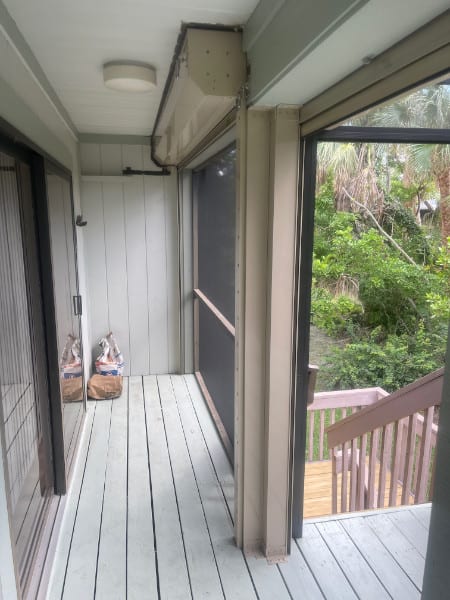 Beige roll down shutters shown in the open position on the back porch of a home in Sanibel Florida. 