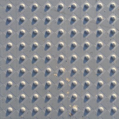 Checkered pattern of small bumps with larger knobs in-between on hard plastic surface